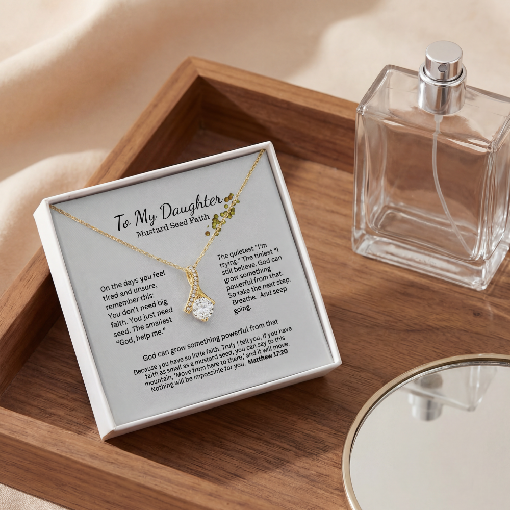 Mustard Seed Faith necklace gift box on a wood table with perfume for an elegant lifestyle flatlay