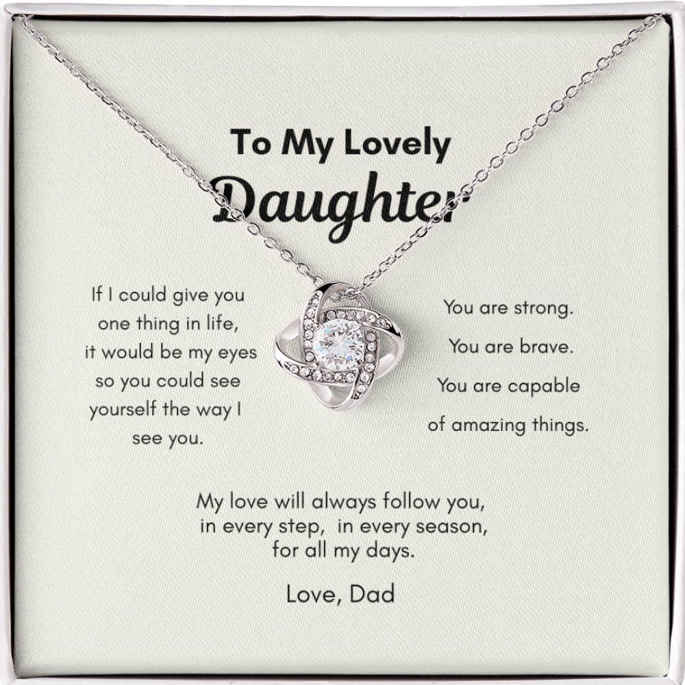 Close up of love knot pendant necklace with cubic zirconia stone on message card