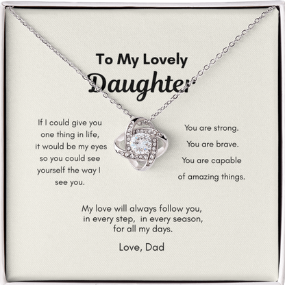 Close up of love knot pendant necklace with cubic zirconia stone on message card